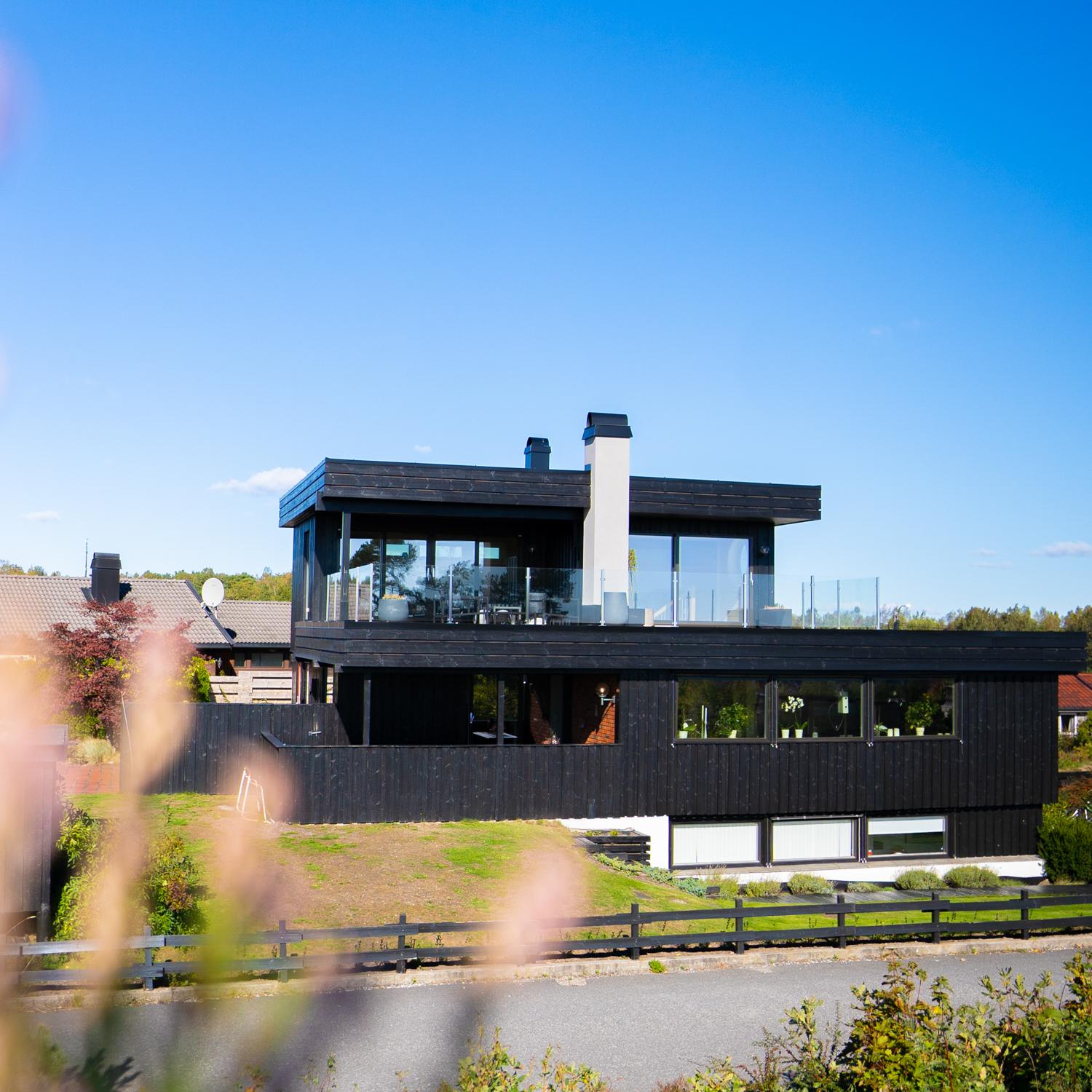 Mørk enebolig med ny loftstue og takterrasse på det flate taket