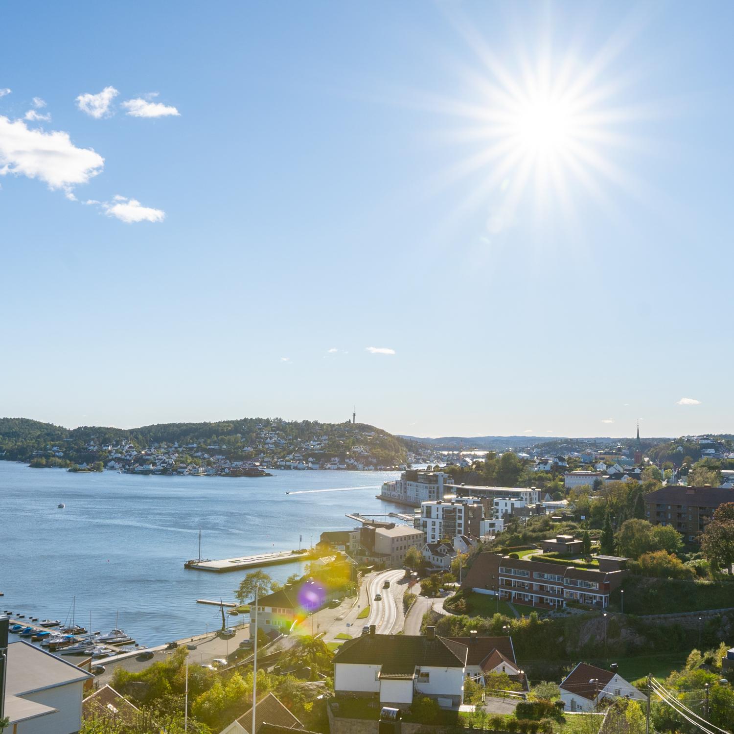 Utsikt fra en takterrasse over byfjorden i Arendal en solrik dag